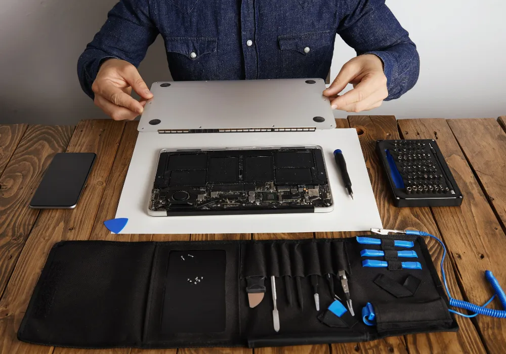 Técnico fazendo manutenção geral em notebook na bancada da JC EletroInfo