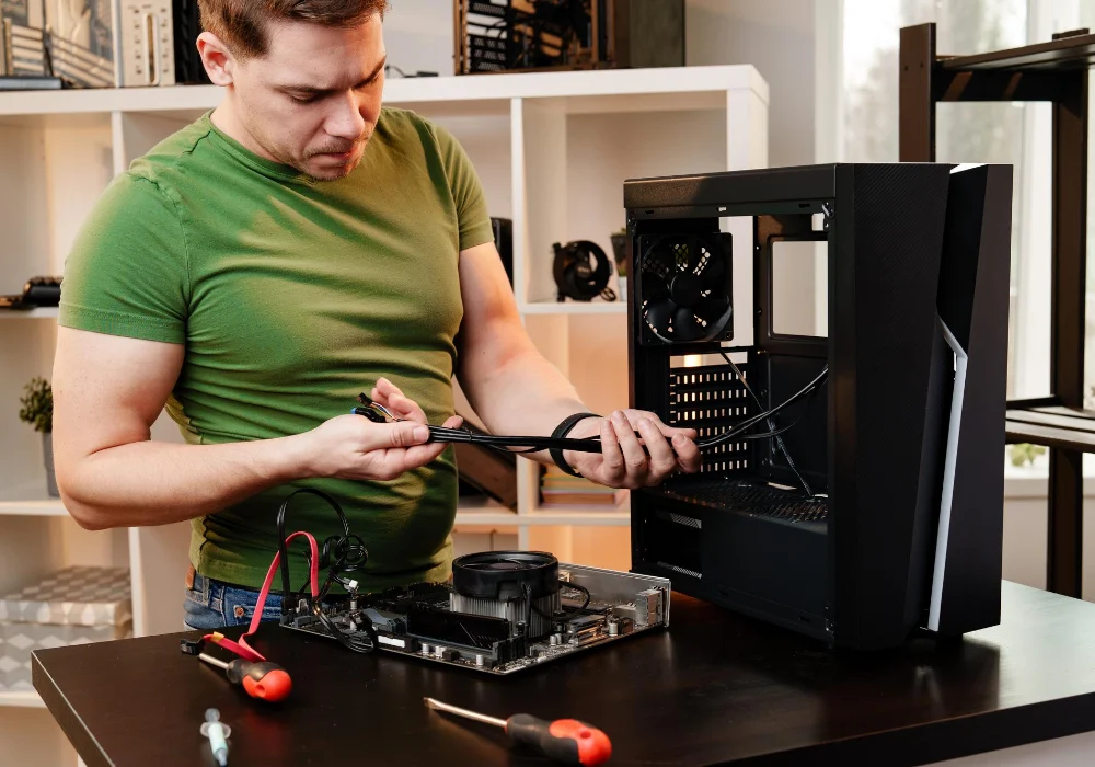 Técnico montando um computador, com o gabinete aberto, placa-mãe e ferramentas sobre a bancada